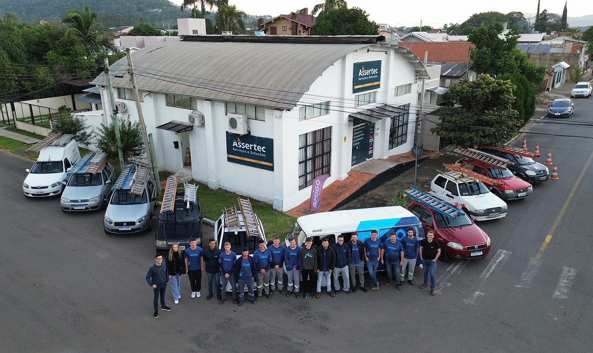 Centro Operacional da Assertec com equipe e veículos técnicos